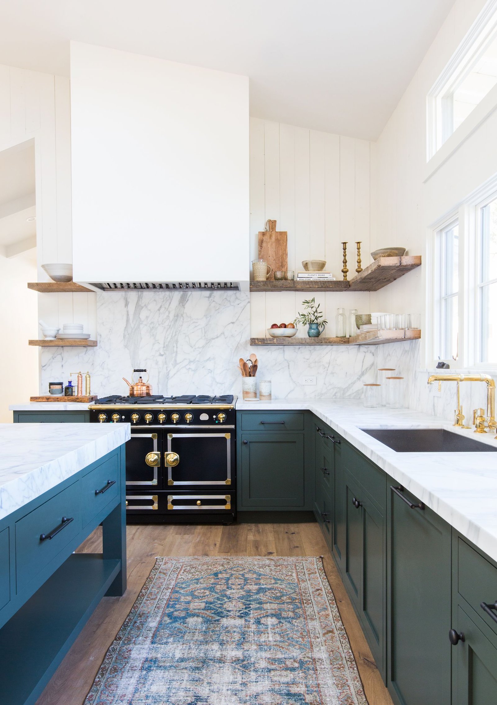 Kitchen with stylish open shelving, featuring neatly arranged dishware, decorative accents, and modern lighting.