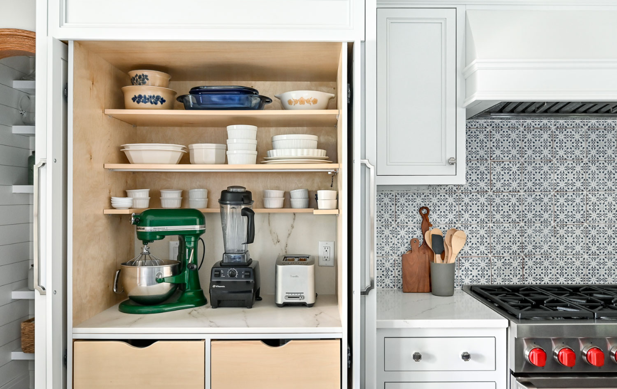 Elegant blue and white kitchen remodel featuring a stylish backsplash, custom cabinetry, and beautiful lighting.