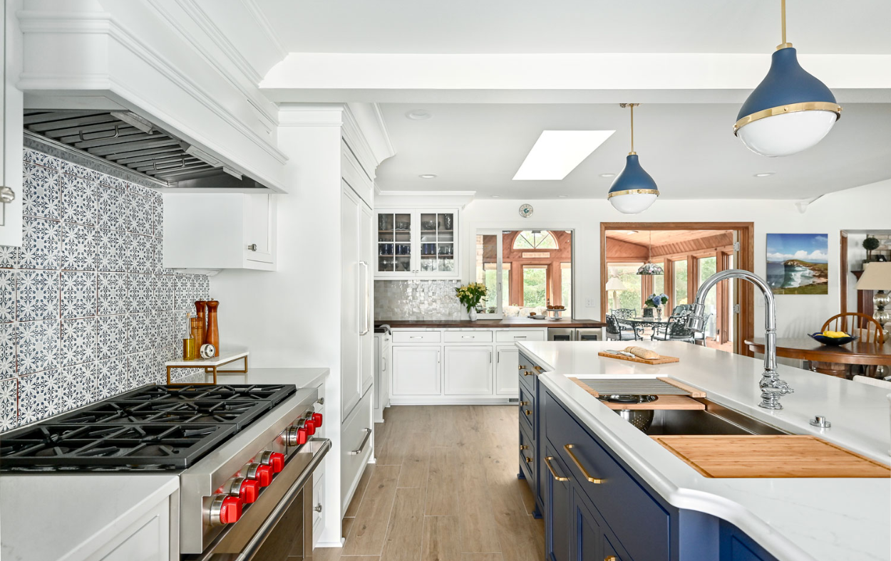 Sleek blue and white kitchen remodel with modern lighting, high-end appliances, and a spacious island for cooking and entertaining.