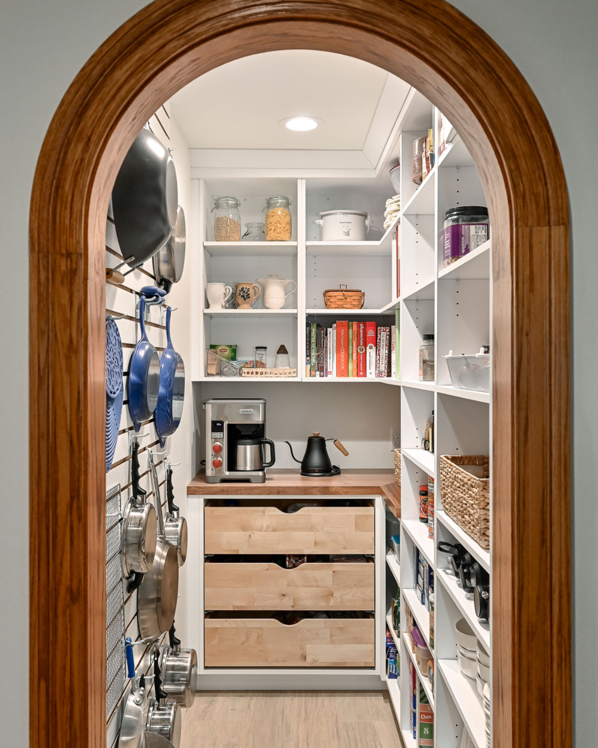 Organized blue and white kitchen remodel with a custom pantry featuring shelving and ample storage space.