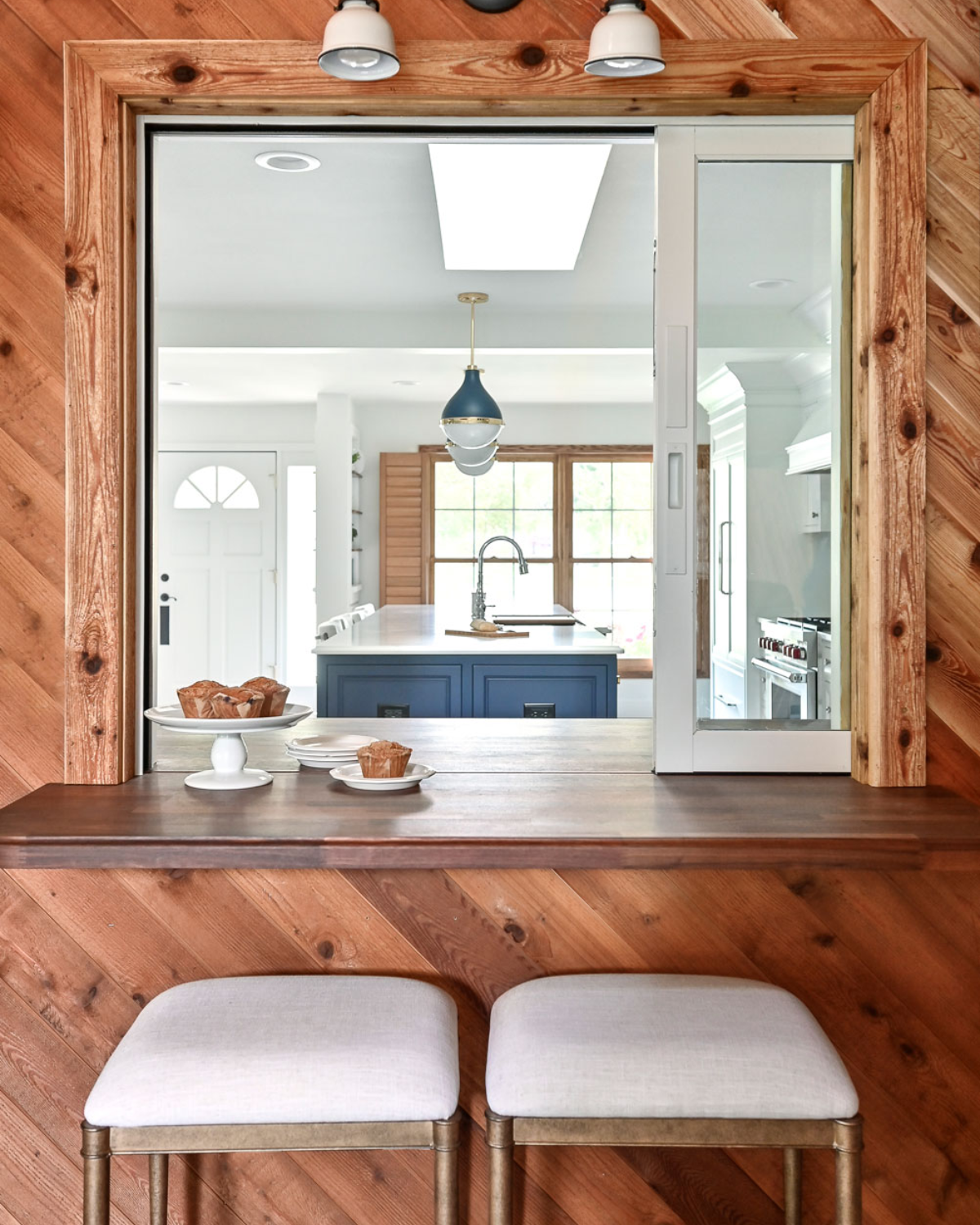 Blue and white kitchen remodel with a stylish built-in bar area featuring modern stools and sleek finishes.