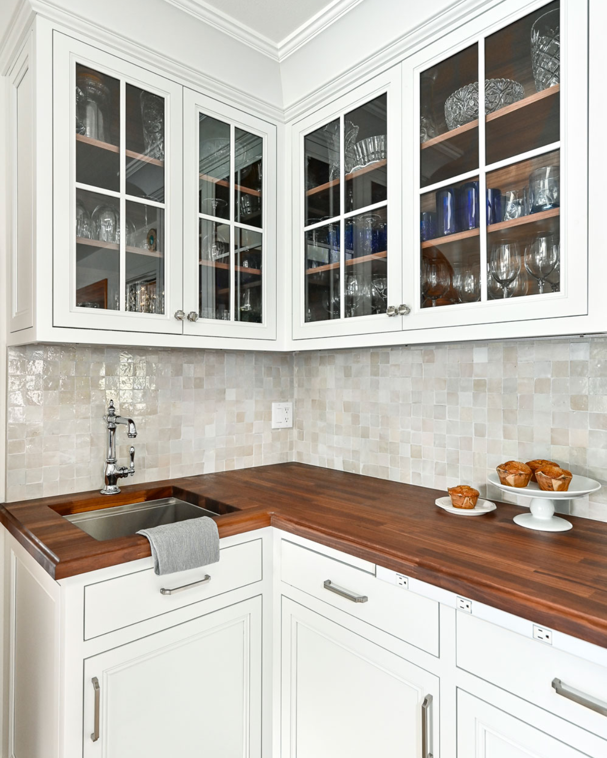 Blue and white kitchen with glass-front cabinets showcasing elegant dishware and decor for a refined look.